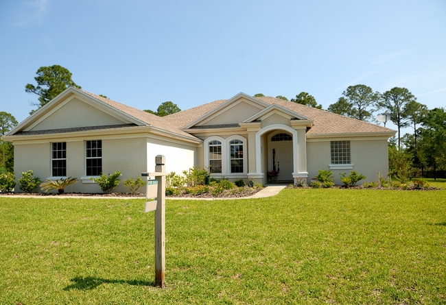 outside of a home with a for sale sign in the front yard