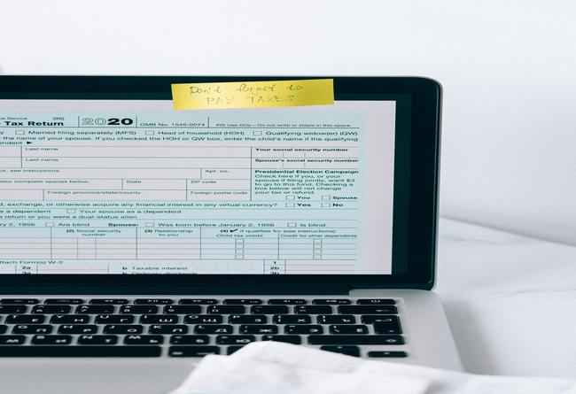 how do tax liens work | computer with a screenshot of tax return and a reminder to fill it in 