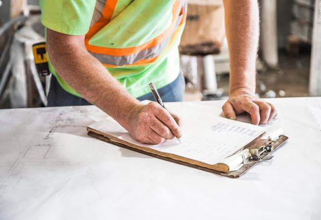 how to fix building code violations | contractor signing off on a piece of paper