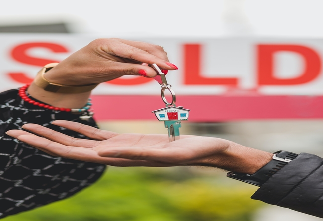 keys being handed over in front of sold sign; can you sell a house with a violation?