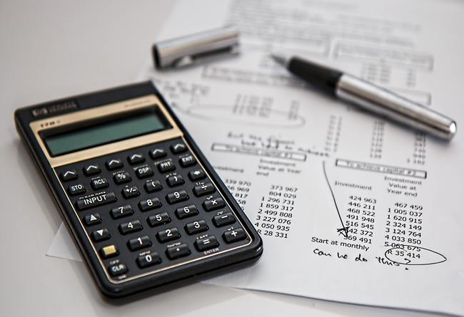 financial calculator with pieces of paper and a pen on a desk | selling property with a lien